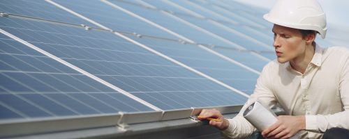 serious-young-man-working-near-solar-panels-4254159