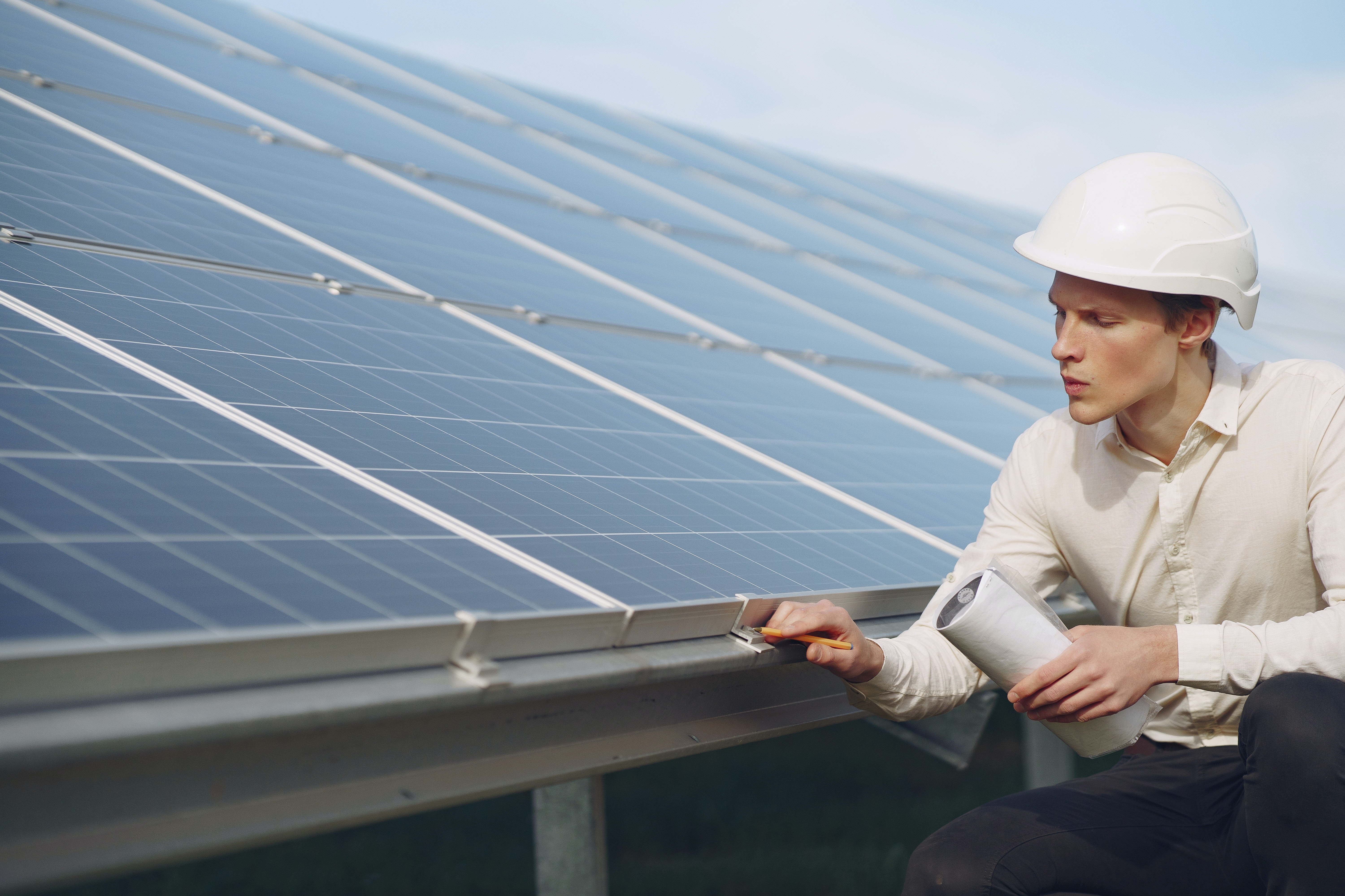 serious-young-man-working-near-solar-panels-4254159